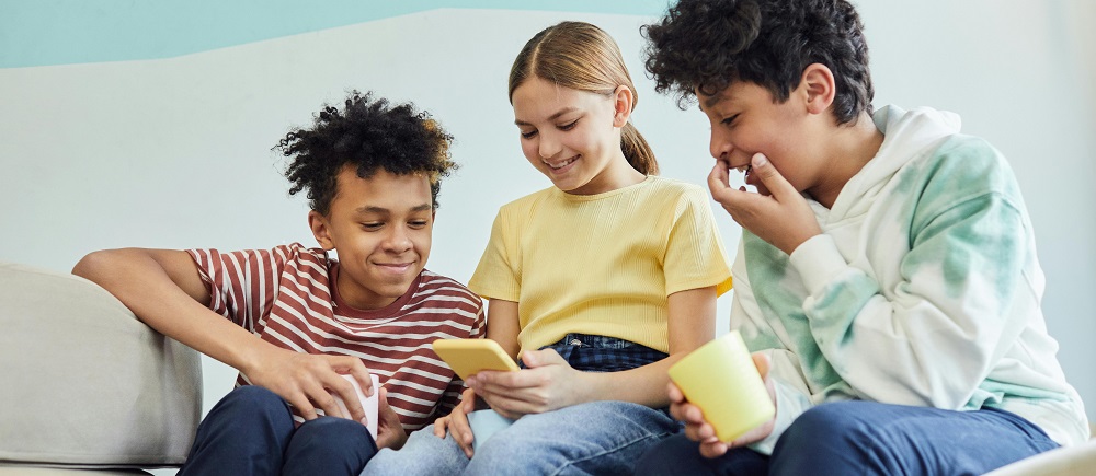 Group of cheerful friends using a smartphone by Vanessa Loring
