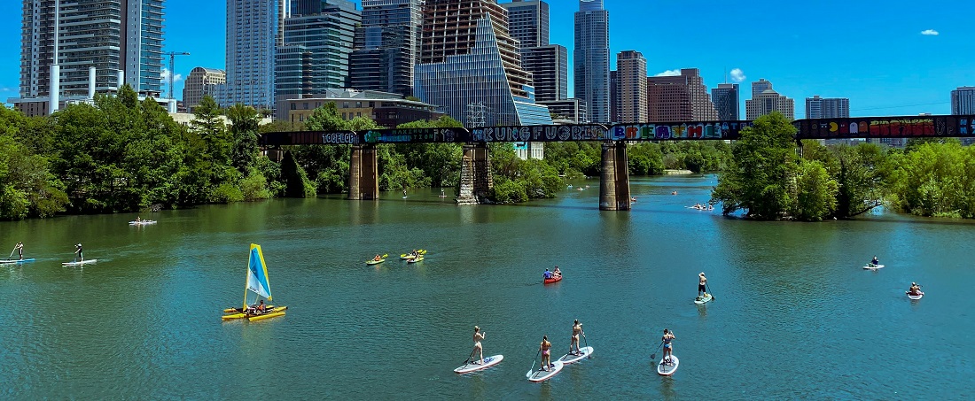 Residents paddleboarding on Lady Bird Lake in Austin by Max Miner