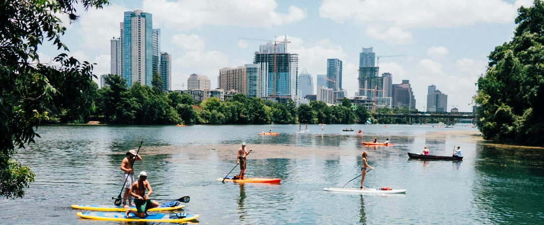 People paddleboarding on a lake in Lou Neff Point by Tomek Baginski