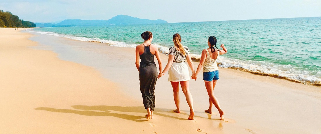 Friends walking on a beach by Julie Aagaard