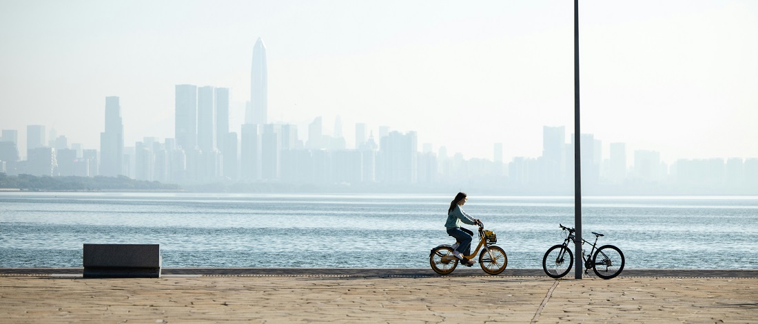 Woman riding a bicycle at Shenzhen Bay by Shengpengpeng Cai