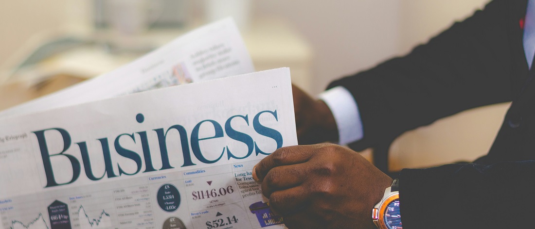 Businessman reading newspaper by Adeolu Eletu