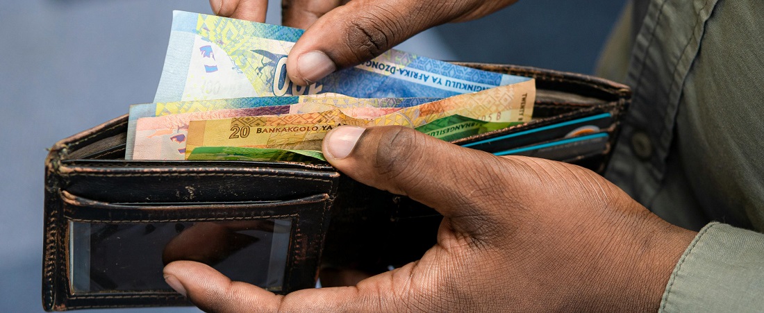 Man holding South African currency notes in wallet by Edge Training
